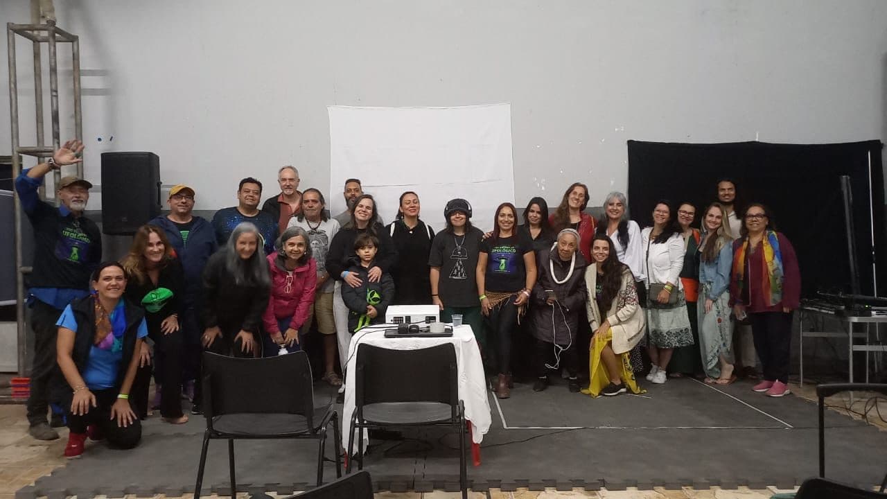 Foto de grupo numa sala, diante da tela de projeção