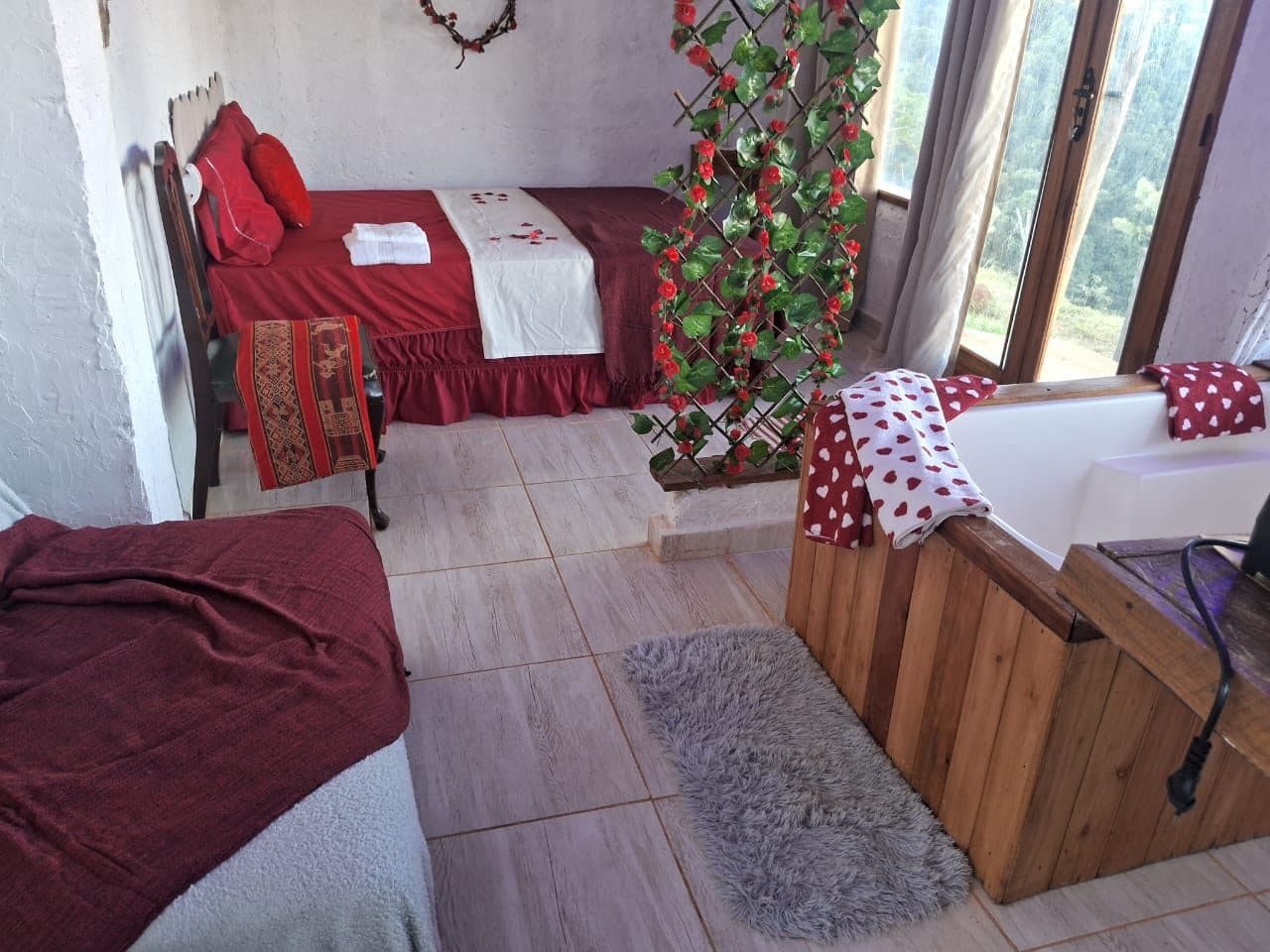 A cama, a banheira e o tapete vistos do canto do quarto